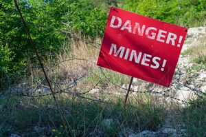 Red-sign-danger-mines-front-minefield-fenced-with-barbed-wire 207254-89(1).jpg
